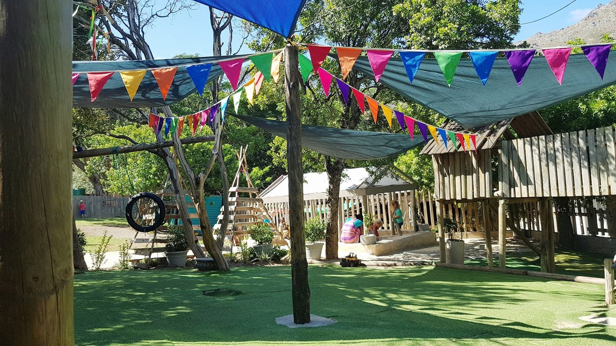 The play garden decorated with bright rainbow bunting and shade sails