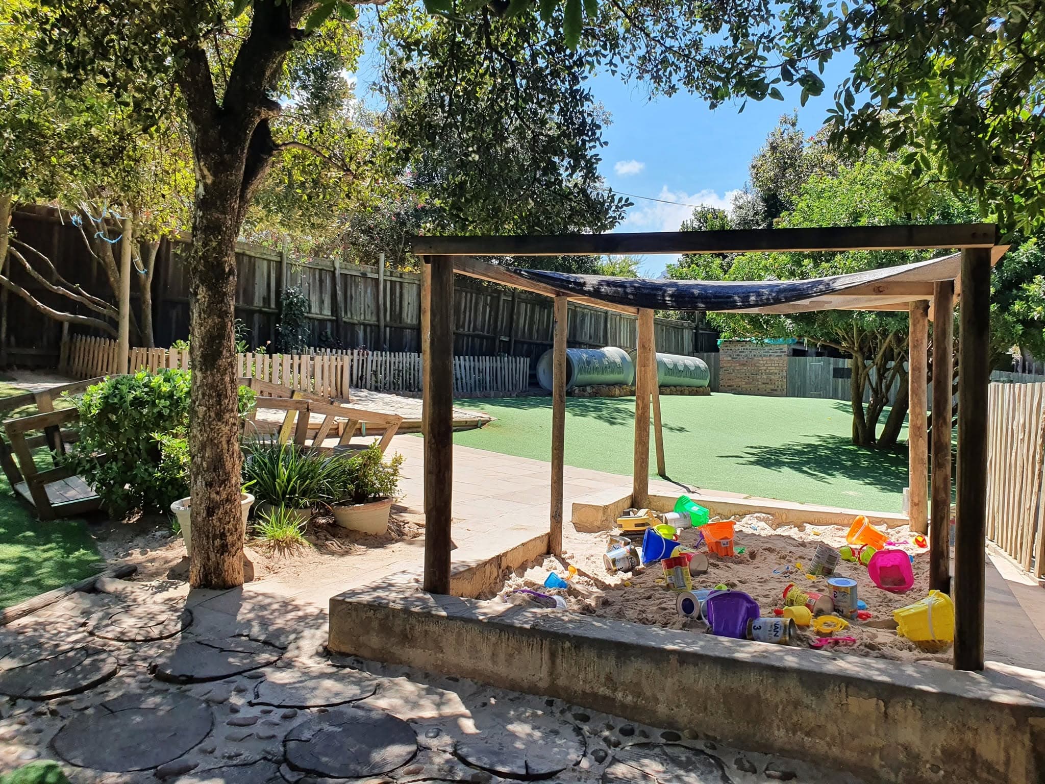 The shaded sandpit and pergola beside the garden pathway