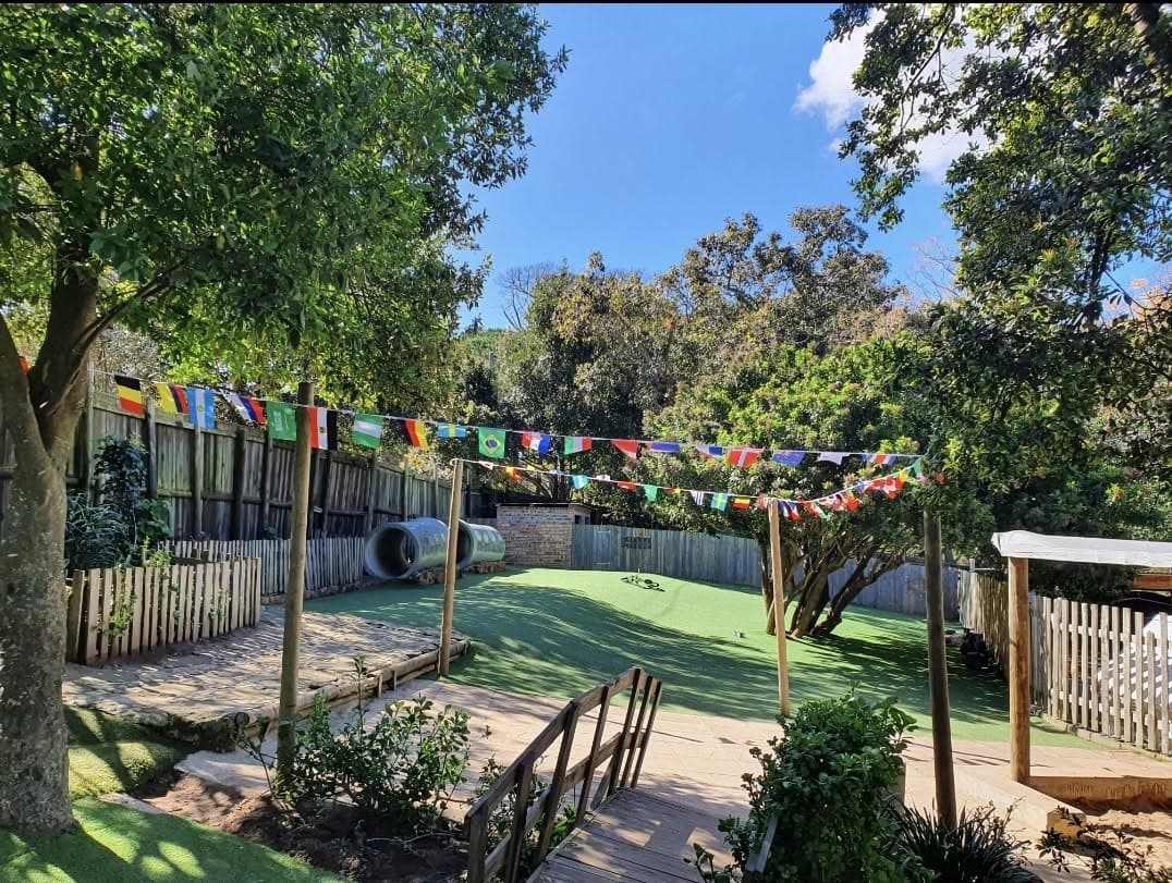 International flag bunting strung across the leafy play garden