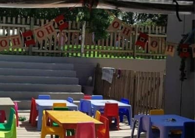 Colourful tables and chairs set up on the outdoor classroom deck